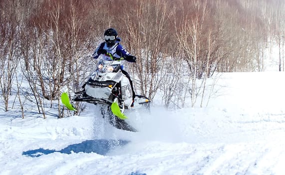 The Snowmobile in high jump above track.