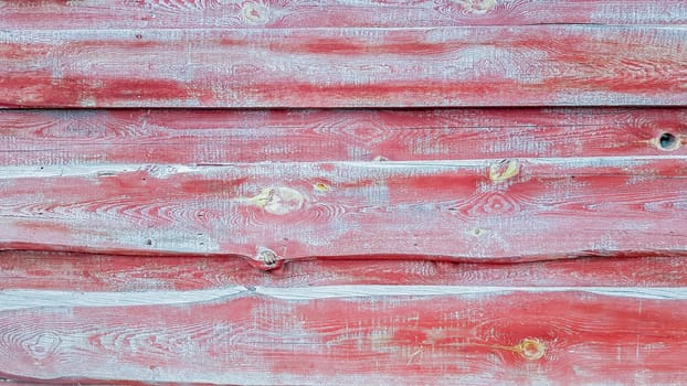 Abstract aged red background for your advertising. The texture of an ancient wood with cracked red paint. Old wooden walls are painted. View from above. copy space