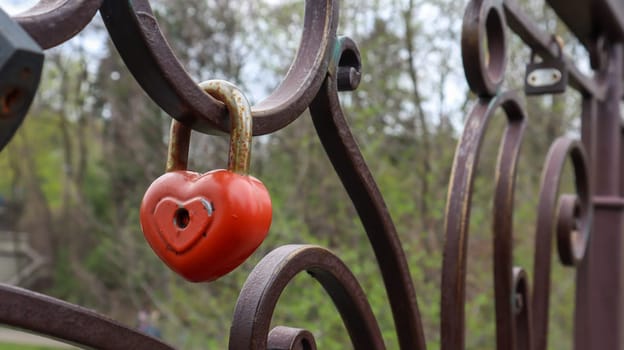 Red padlock metal love heart shaped lock on the bridge. The concept of love. Valentine's day background