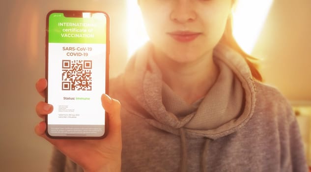 Traveler shows health passport of vaccination certification on phone. Vaccination passport for COVID-19 displayed on smartphone. Vaccination, disease immunity passport health and surveillance concepts