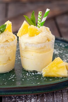 Delicious pineapple soft serve with coconut flakes and mint leaves
