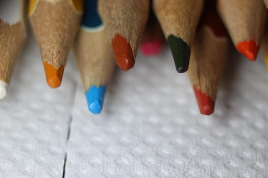 Close-up view of bright colored multicolor pencils on black background