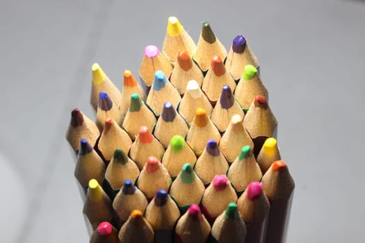 Close-up view of bright colored multicolor pencils on black background