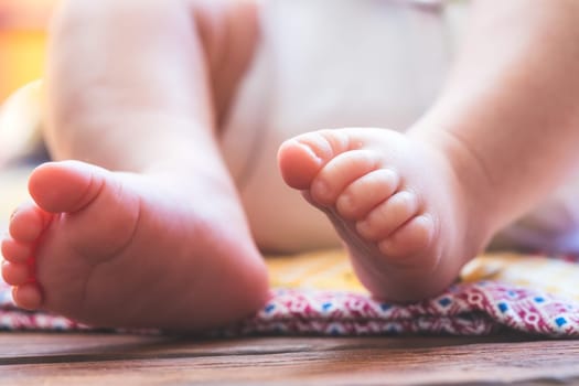 Close up of newborn baby feet, outdoors on baby blanket