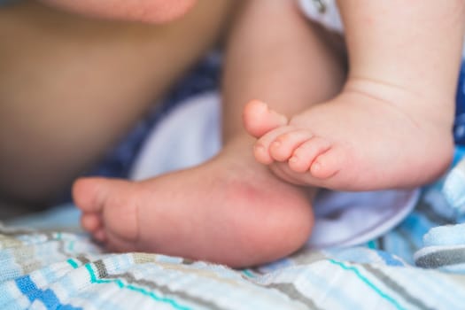Close up of newborn baby feet on baby blanket