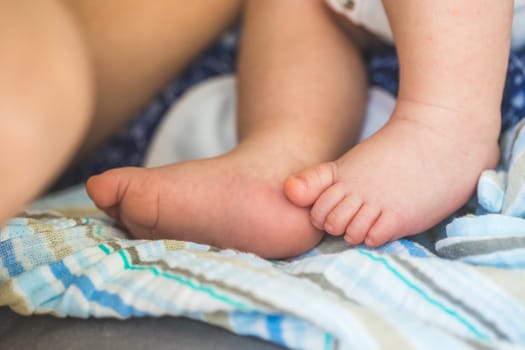 Close up of newborn baby feet on baby blanket