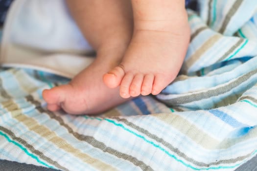 Close up of newborn baby feet on baby blanket