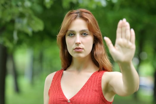 Serious woman gesturing stop with her hand in a park