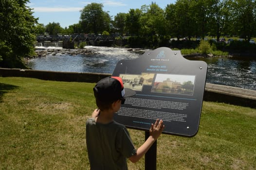SMITHS FALLS, ONTARIO, CA, JUNE 12, 2021: Historic site of the Woods Mill on the Rideau Canal located in Smiths Falls, On showing the falls of the canal in the background.