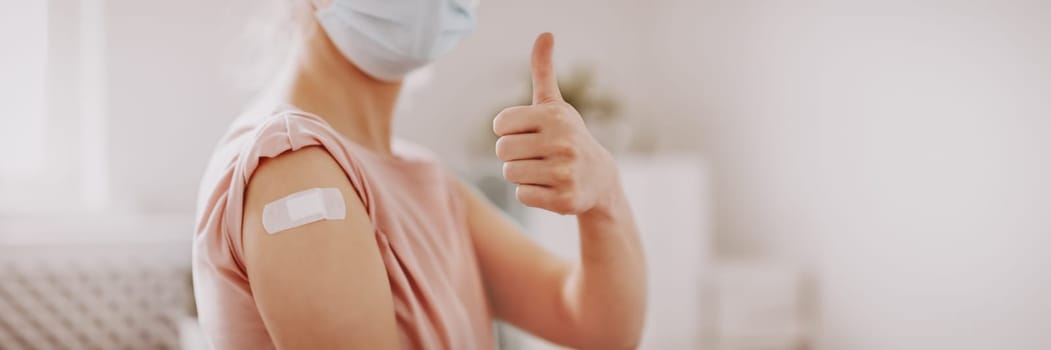 Woman showing thumb up after inoculation against Covid 19. Concept of immunization and making injections from pandemic of SARS.