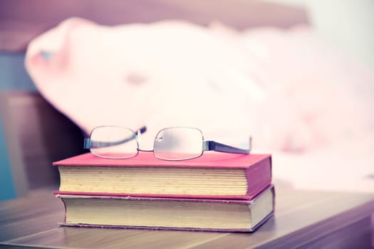 Book on a nightstand table in the bedroom on a sunny morning
