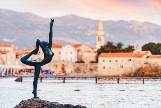 Sculpture of dancer girl in Budva, Montenegro, Balkans, Europe. Old town and mountains in backround.