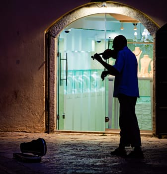 Street artist playing violin in old town Budva, Montenegro, Balkans, Europe.