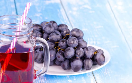 The grape juice or smoothie on an old blue wooden table
