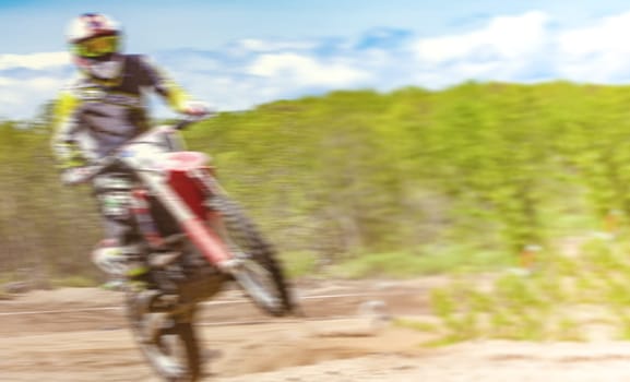 The Blurred Motocross riders practice tricks on their dirt bikes on a sunny day in Kamchatka