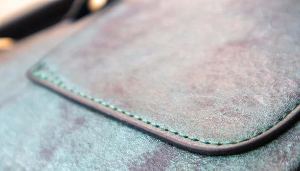 Detail of a fashionable leather bag close up. Fashion concept. Details of sewing threads, macro photography. Stylish female accessory