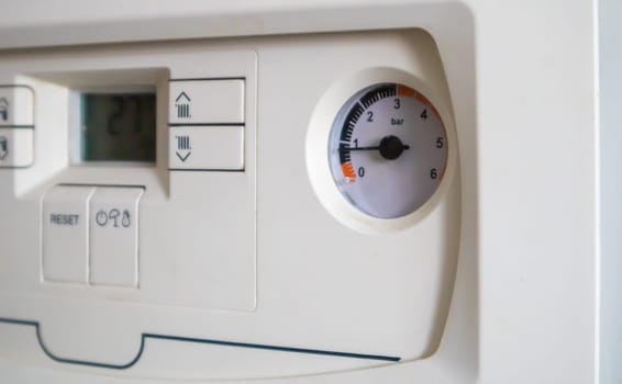 Internal control of a gas double-circuit boiler with a pressure and temperature sensor in the home heating system, close. Energy saving and image efficient home concept. Selective focus