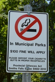 SMITHS FALLS, ONTARIO, CA, JUNE 16, 2021: Smoking bylaw sign posted in Centennial Park of Smiths Falls, Ontario during spring of 2021.