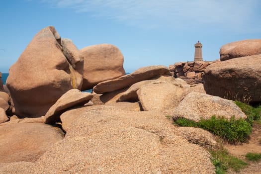 Pink granite boulders and lighthouse, ploumanach coast, Brittany, France