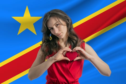 Love Democratic Republic of the Congo A girl holds a heart on her chest in her hands against the background of the flag