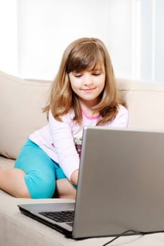 Beautiful happy little girl with laptop