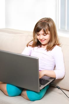Beautiful happy little girl with laptop