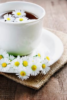 Cup of natural tea on wooden background