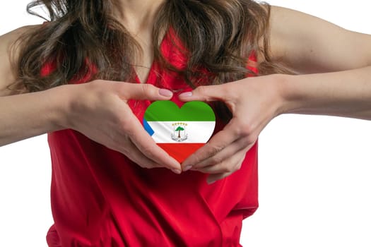 Love Equatorial Guinea The woman holds a heart in the form of the flag of Equatorial Guinea on her chest. Concept of patriotism.