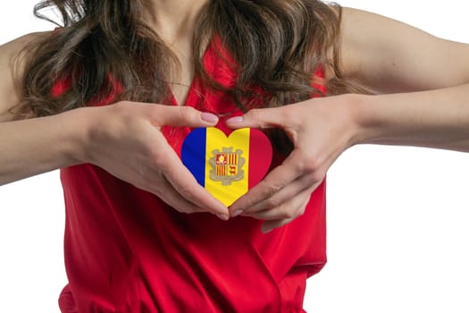 Love Andorra. The woman holds a heart in the form of the flag of Andorra on her chest. Concept of patriotism.