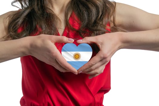 Love Argentina. The woman holds a heart in the form of the flag of Argentina on her chest. Concept of patriotism.