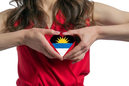 Love Antigua and Barbuda. The woman holds a heart in the form of the flag of Antigua and Barbuda on her chest. Concept of patriotism.