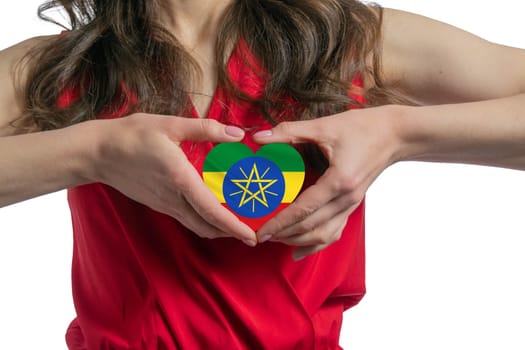 Love Ethiopia The woman holds a heart in the form of the flag of Ethiopia on her chest. Concept of patriotism.