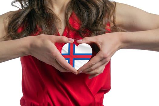Love Faroe Islands. The woman holds a heart in the form of the flag of Faroe Islands on her chest. Concept of patriotism.