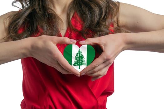 Love Norfolk Island. The woman holds a heart in the form of the flag of Norfolk Island on her chest. Concept of patriotism.