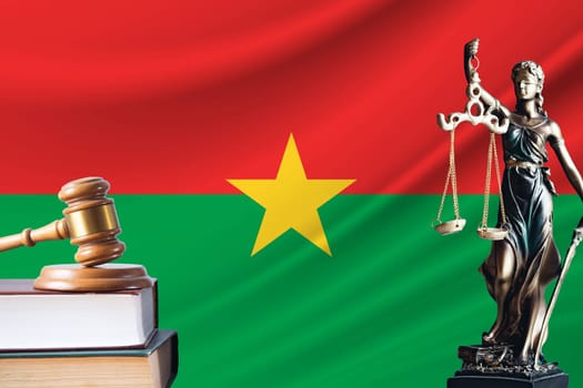 Law and justice in Burkina Faso. Statue of themis and the gavel of the judge against the background of the flag of Burkina Faso. Law and justice concept.