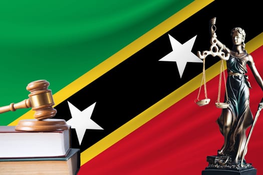 Law and justice in St. Kitts and Nevis. Statue of themis and the gavel of the judge against the background of the flag of St. Kitts and Nevis. Law and justice concept.