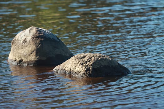 river landscape with granite boulders in blue water