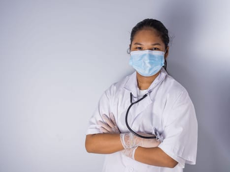 Studio portrait of a female doctor wearing a mask standing on a white background There was a slight light on his face.
