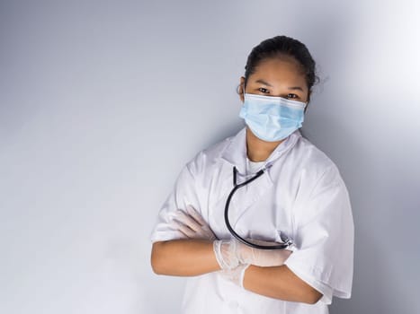 Studio portrait of a female doctor wearing a mask standing on a white background There was a slight light on his face.