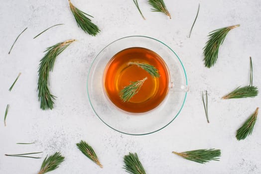 Pine needle tea in a cup on a white textured background, empty copy space for text, hot drink