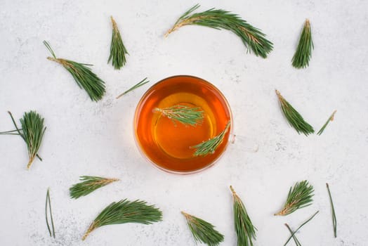 Pine needle tea in a cup on a white textured background, empty copy space for text, hot drink