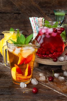 Ice cold beverages with fresh fruits in glass pitchers