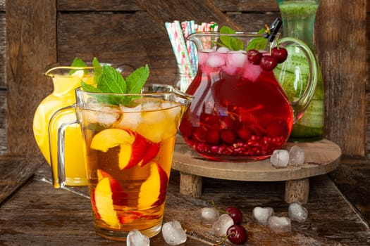 Ice cold beverages with fresh fruits in glass pitchers