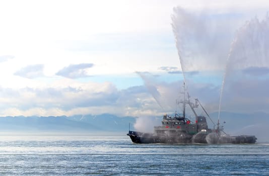 the Floating tug boat is spraying jets of water