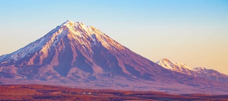 Panoramic view of the city Petropavlovsk-Kamchatsky and volcanoes: Koryaksky Volcano, Avacha Volcano, Kozelsky Volcano. Russian Far East, Kamchatka Peninsula.