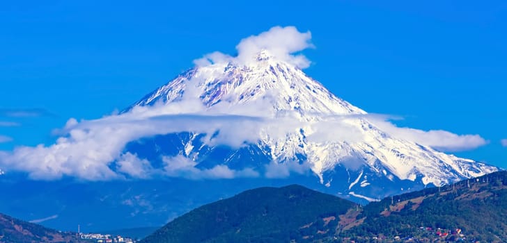 Panoramic view of the city Petropavlovsk-Kamchatsky and volcanoes: Koryaksky Volcano, Avacha Volcano, Kozelsky Volcano. Russian Far East, Kamchatka Peninsula