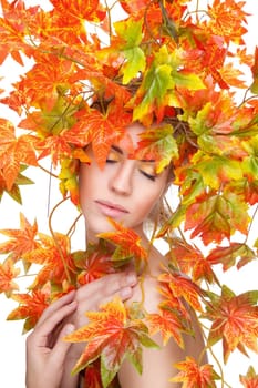Beautiful young woman wrapped in autumn leafs