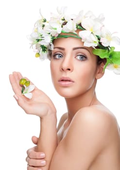 Young beauty with perfect skin wearing a crown from flowers on white