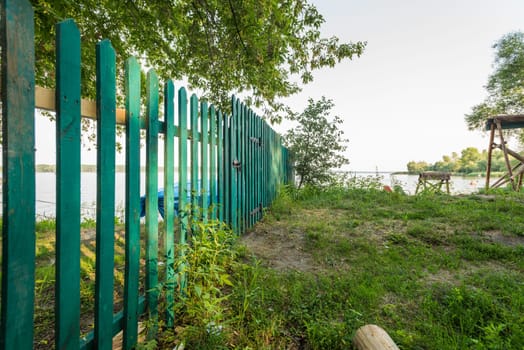 Wood green fence of riverside house