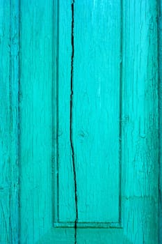 Fragment of old cracked wooden board painted in turquoise color